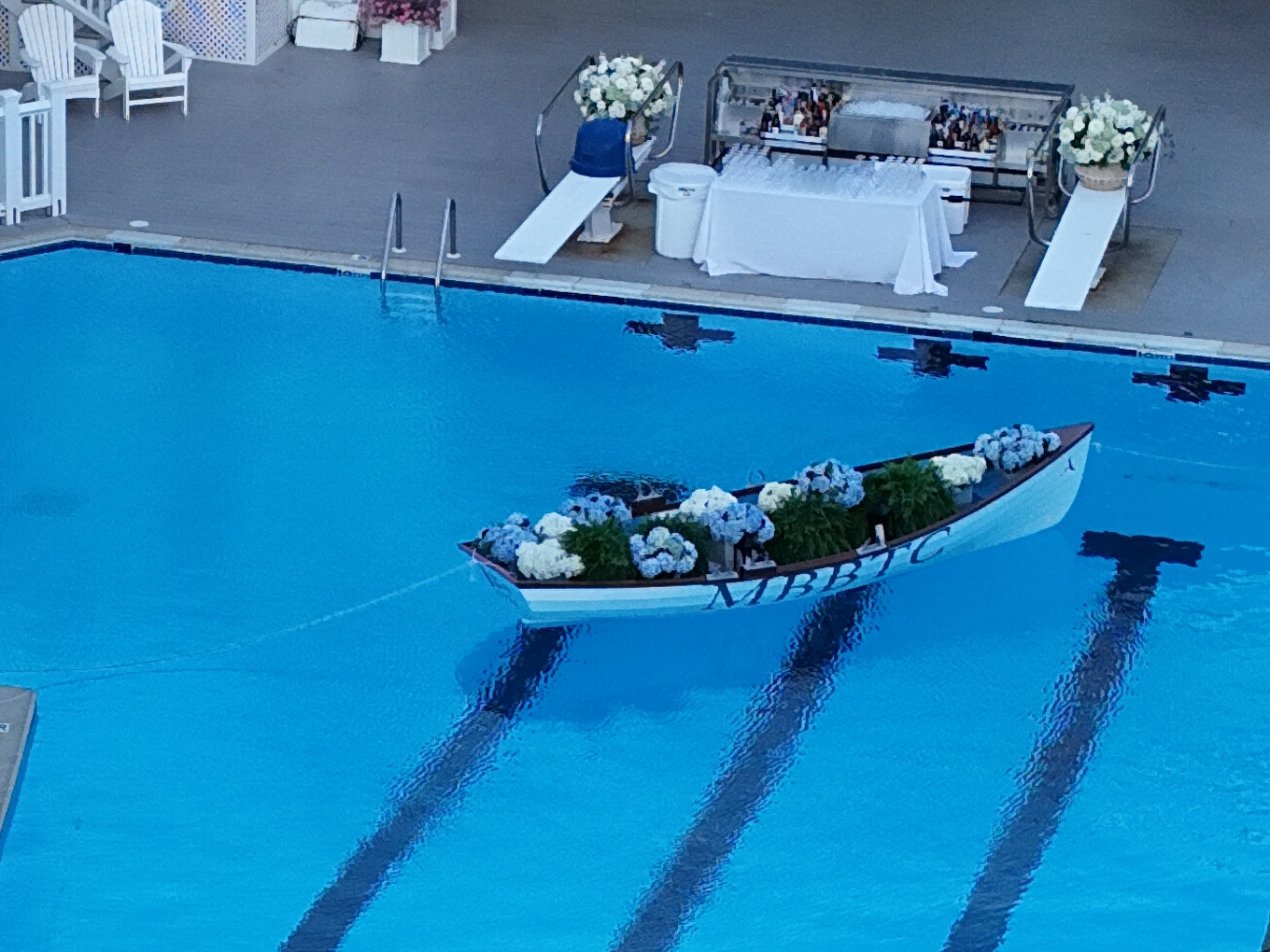 A canoe filled with blue and white hydrangeas floating in the pool at Monmouth Beach Bath & Tennis Club.